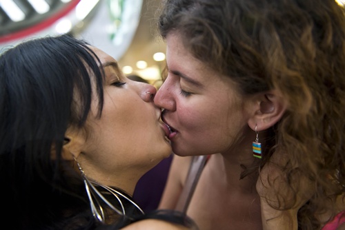 March 8, 2019 - Milano, Lombardia, Italy - A woman without a bra is seen  asking for body freedom next to a couple kissing during the protest..The  network Non Una di Meno